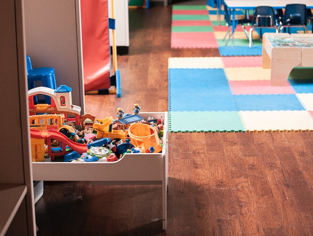 nursery room with colourful carpet and drawer full of toys